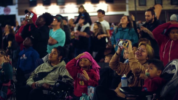 An image of a crowd of families watching an NLDS drone show.
