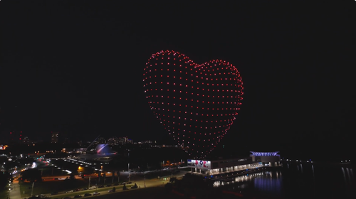 An image depicting an NLDS drone show over a beach front.