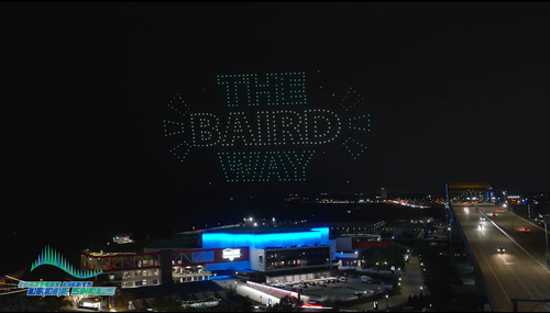 An image from an NLDS drone show depicting a company's logo and tagline. An image from an NLDS drone show depicting a company's logo and tagline.