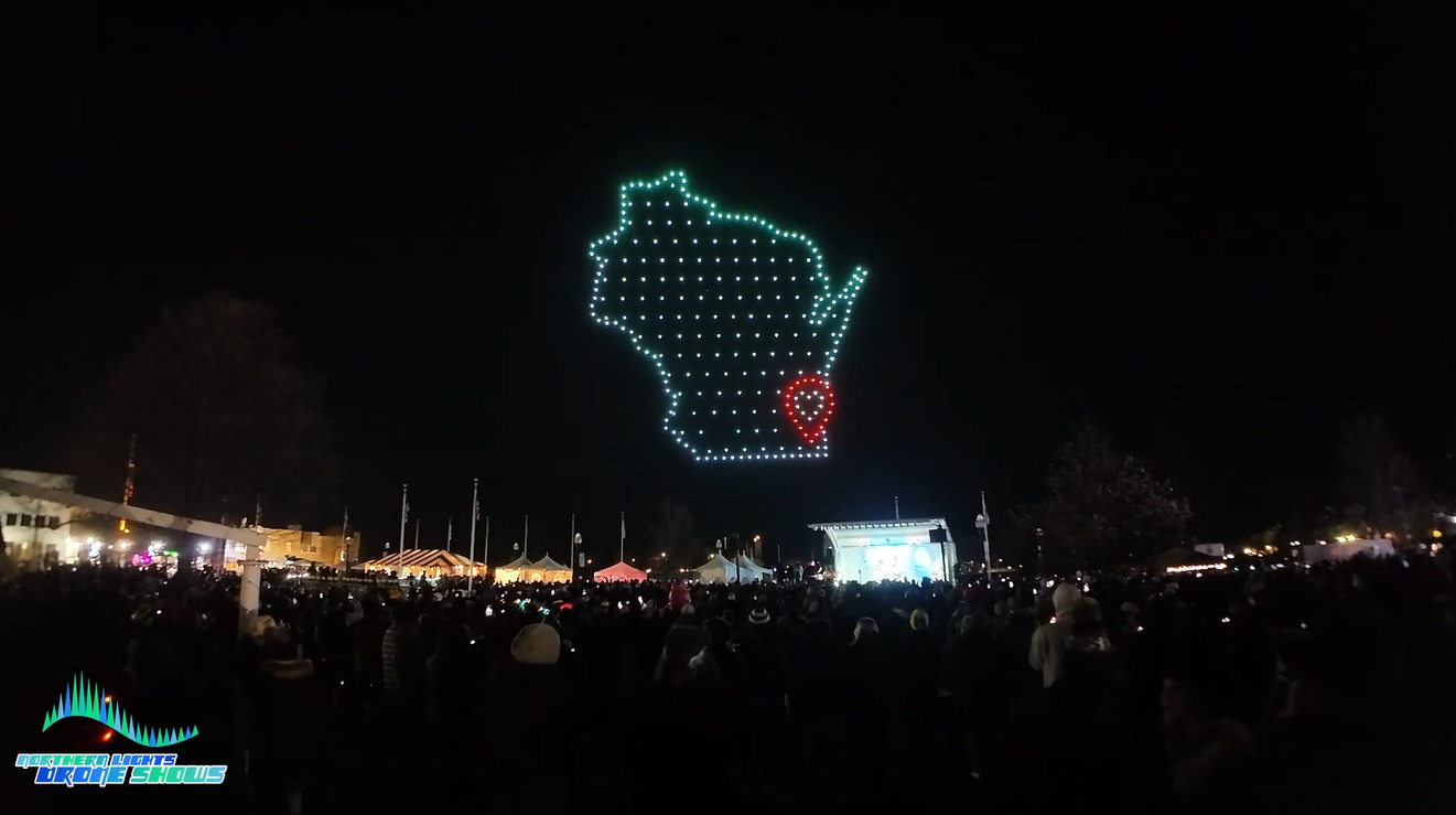 An image depicting a crowd at a festival in Wisconsin watching a drone show from the Northern Lights Drone Shows. An image depicting a crowd at a festival in Wisconsin watching a drone show from the Northern Lights Drone Shows.