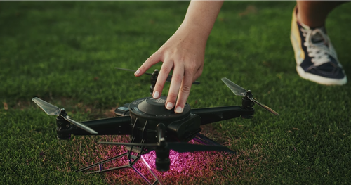 An image from an NLDS drone show depicting a member of our flight crew manually activating one of our drones prior to a show.