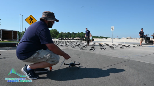 An image depicting an NLDS flight crew member and pilots setting up the drone show in a safe manner.