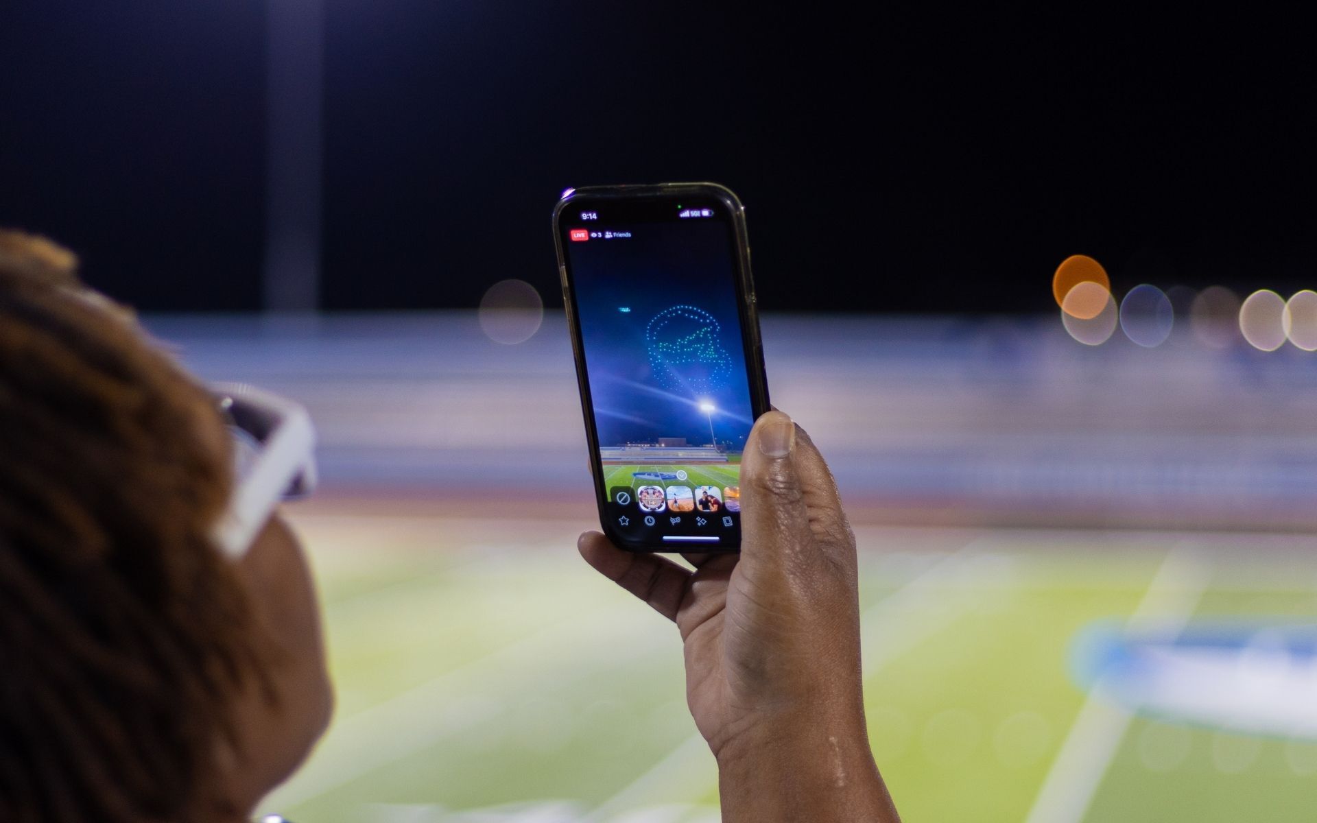 An image from an NLDS drone show depicting an attendee recording the show.