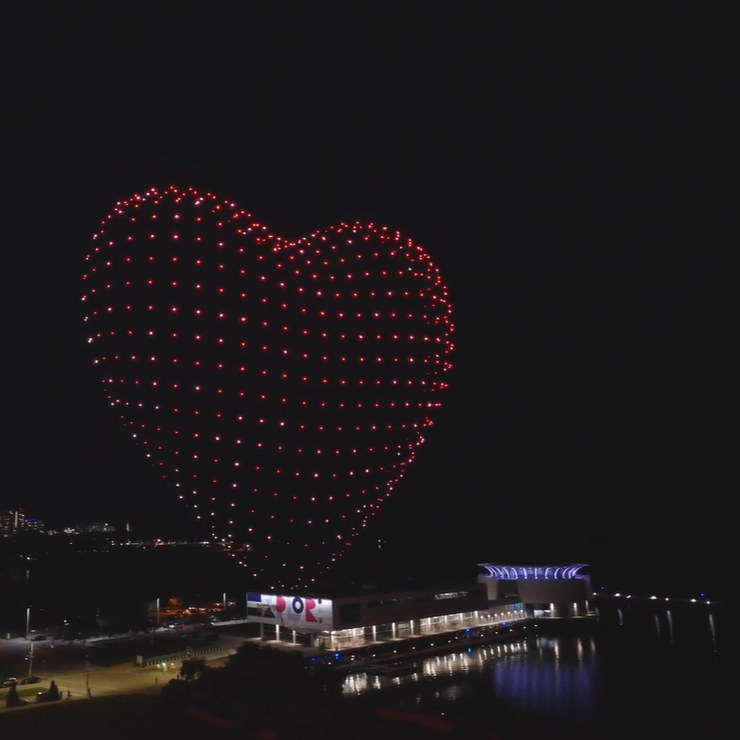 An image from an NLDS drone show featuring a 3D heart over a waterfront crowd. An image from an NLDS drone show featuring a 3D heart over a waterfront crowd.