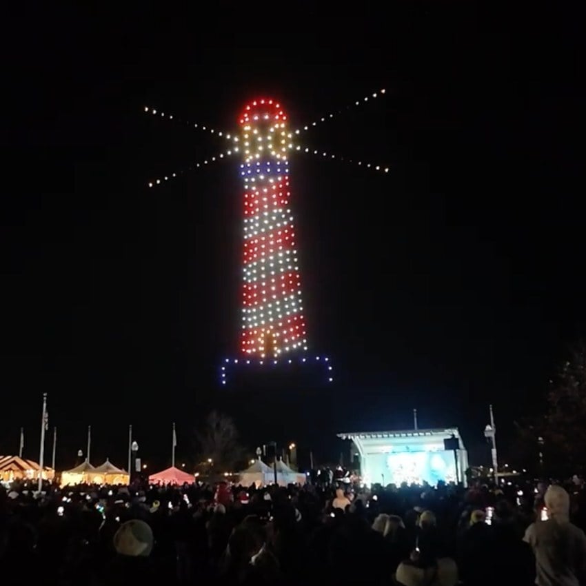 An image from an NLDS drone show featuring a lighthouse at a holiday waterfront event. An image from an NLDS drone show featuring a lighthouse at a holiday waterfront event.