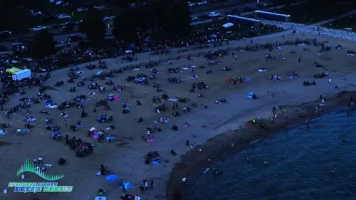 An image from an NLDS drone show depicting the huge crowd gathered on the beach to watch the show. An image from an NLDS drone show depicting the huge crowd gathered on the beach to watch the show.