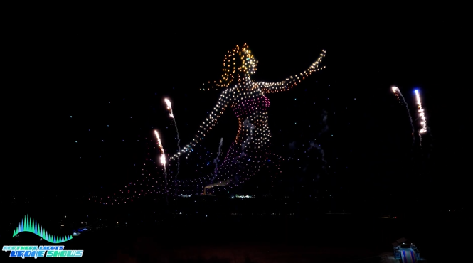 An image of 1000 drones comprising the shape of a mermaid with pyro drones. An image of 1000 drones comprising the shape of a mermaid with pyro drones.