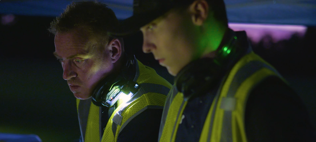 An image from an NLDS drone show featuring two groundcrew members figuring out a problem. An image from an NLDS drone show featuring two groundcrew members figuring out a problem.