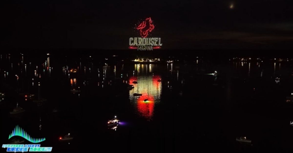 An image from an NLDS drone show featuring a sponsor ad beautifully placed above the lake towards the end of a drone show. An image from an NLDS drone show featuring a sponsor ad beautifully placed above the lake towards the end of a drone show.