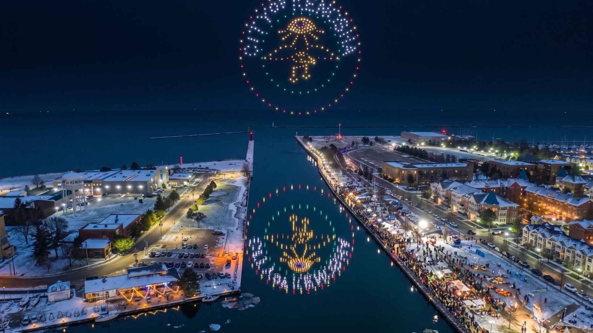 An image from the Kenosha Lightin' Up show featuring the logo over a canal in front of a crowd of spectators.